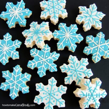 Snowflake Rice Krispie Treats decorated with blue and white chocolate.