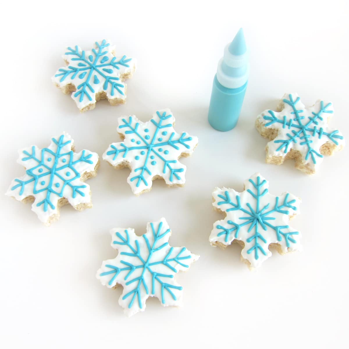 white chocolate covered Rice Krispie Treats decorated with blue candy melts snowflakes.