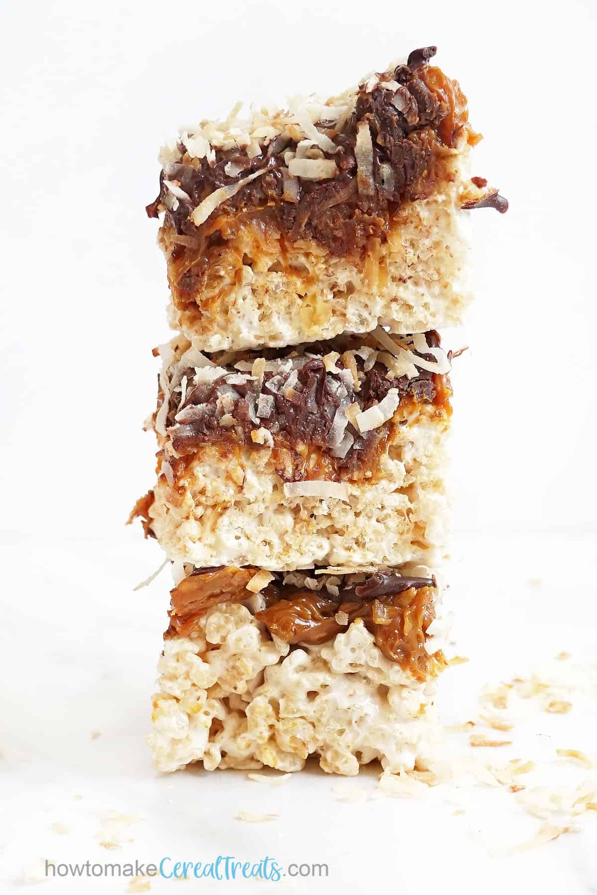 stack of caramel topped Rice Krispie Treats with toasted coconut and chocolate