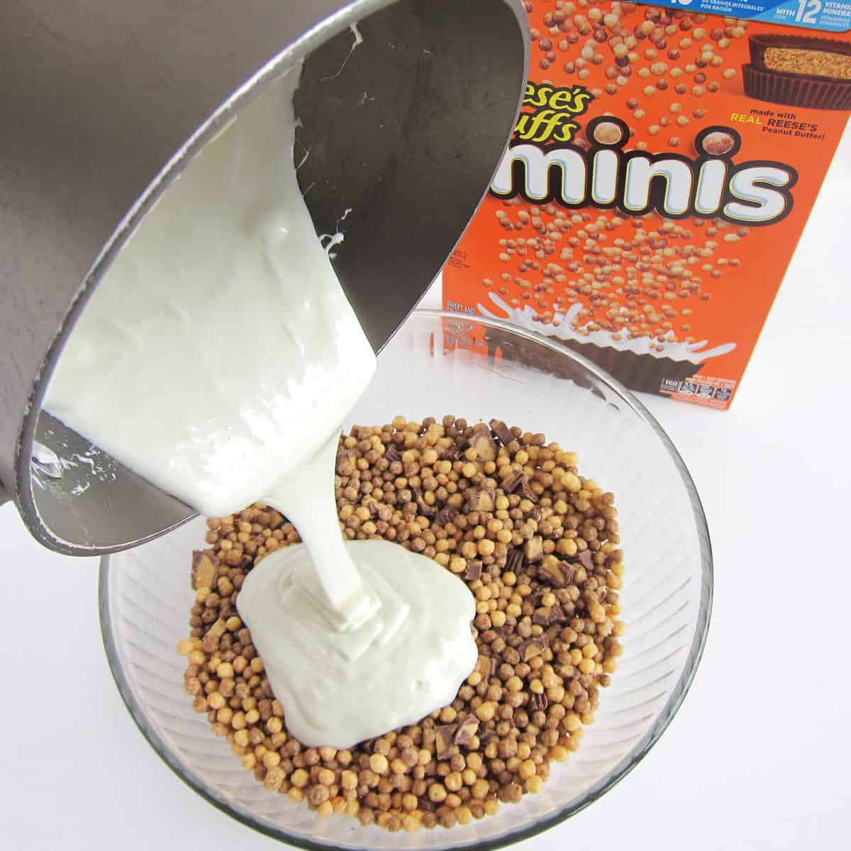 Pouring melted butter and marshmallows over a bowl of Reese's Puffs Minis.