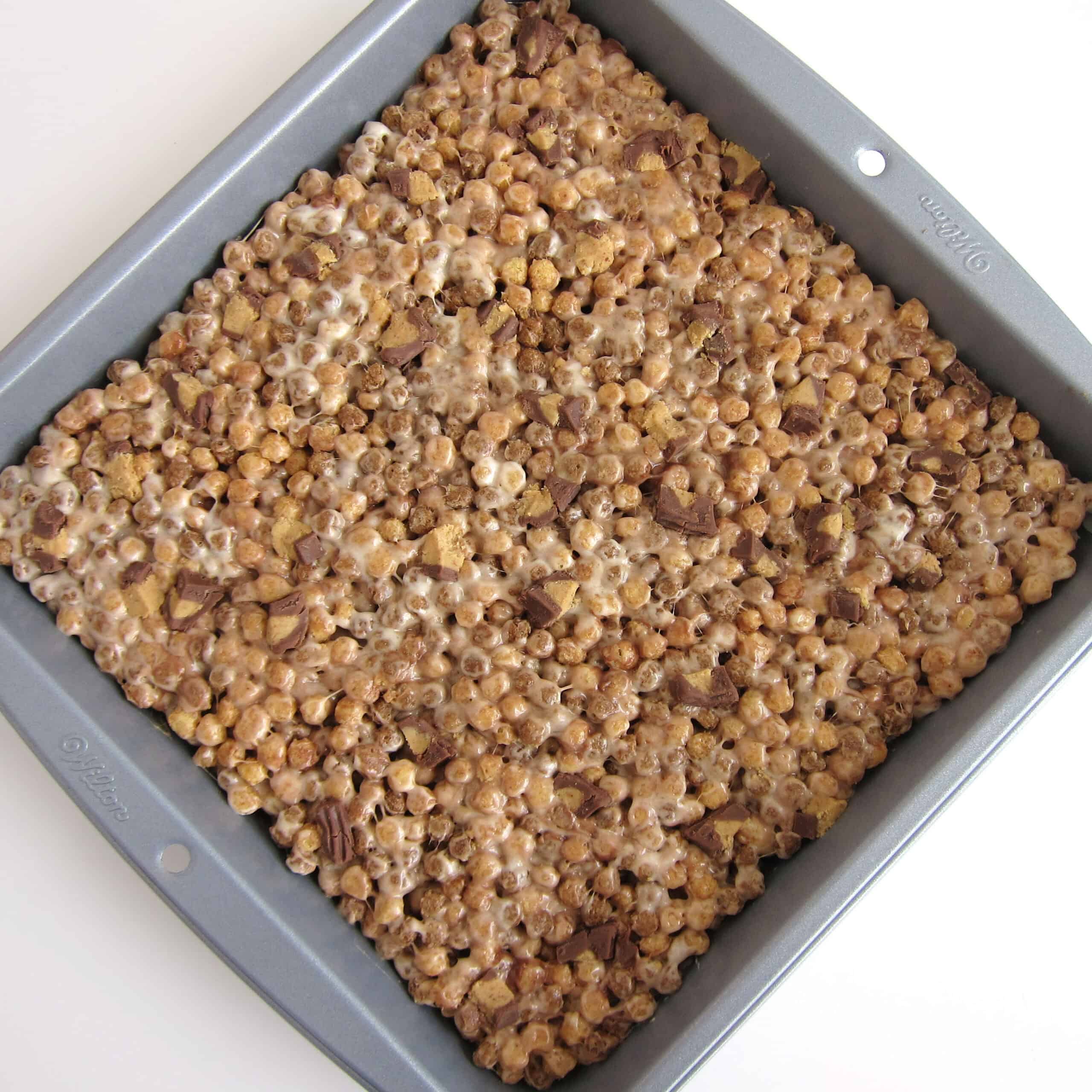 pan of homemade rice crispy treats made using Reese's Puffs Minis cereal and Reese's Cups.